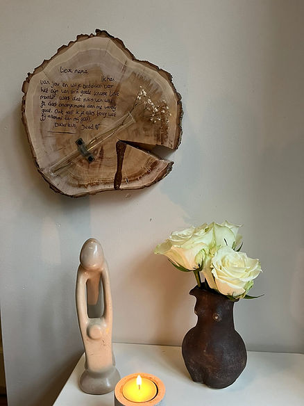 Herdenken, houtschijf, moeder en dochter beeldje, bloemen, kaarsje branden